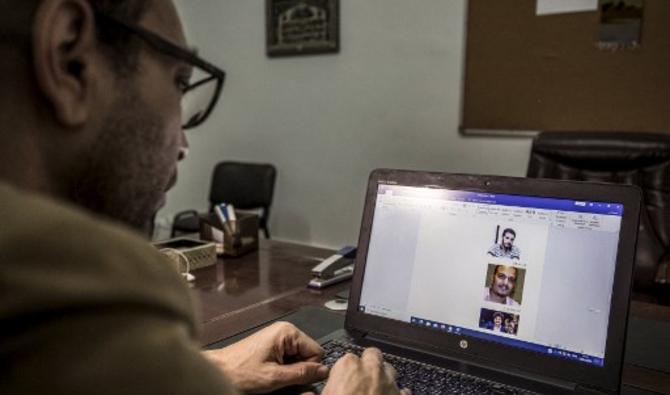 Le militant égyptien des droits Mohamed Lotfy, qui est directeur exécutif de la Commission égyptienne des droits et de la liberté (ECRF) basée au Caire, parcourt des images de militants détenus sur son ordinateur portable dans la capitale Le Caire, le 10 janvier 2020. (Photo, AFP)
