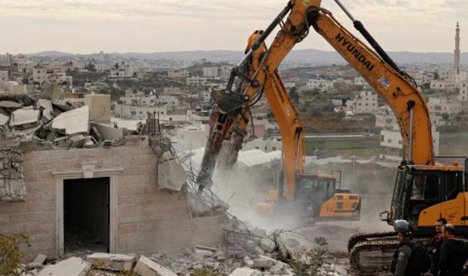 Les forces de sécurité israéliennes montent la garde lors de la démolition d'une maison palestinienne, dans la ville occupée d'Hébron en Cisjordanie, le 28 décembre 2021. (Photo, AFP)