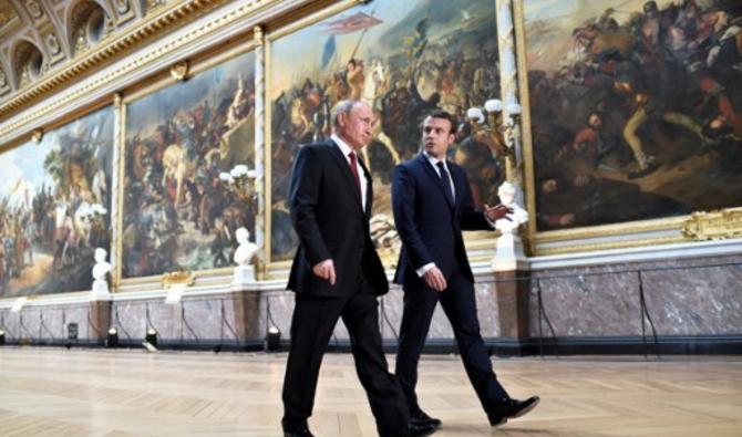 Le président français Emmanuel Macron s'adresse au président russe Vladimir Poutine dans la Galerie des Batailles à leur arrivée pour une conférence de presse conjointe à la suite de leur rencontre au Château de Versailles, près de Paris, le 29 mai 2017. (Photo, AFP)