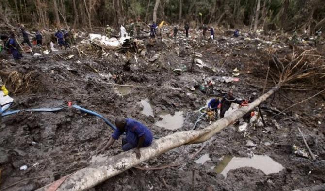 Des soldats et des pompiers camerounais fouillent la boîte noire de l'avion de Kenya Airways, le 10 mai 2007, autour de l'épave dans la forêt de Mbanga Pongo, près de la ville de Douala, au Cameroun. (Photo, AFP)