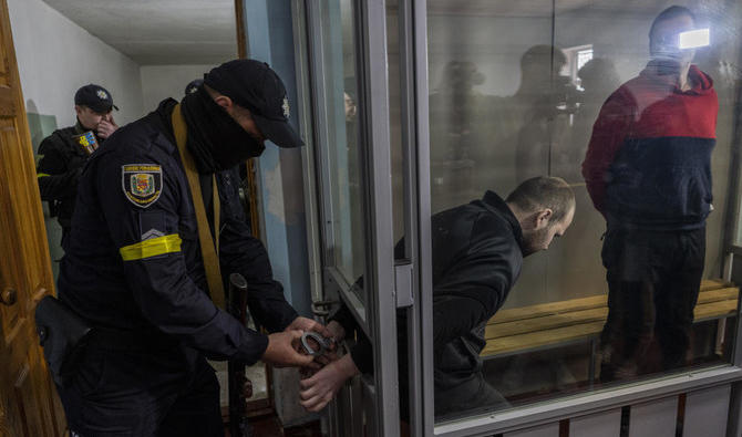 Les soldats russes capturés Alexander Alexeevich Ivanov et Alexander Vladimirovitch Bobykin, à droite, quittent la salle d'audience après leur procès à Kotelva, dans le nord-est de l'Ukraine. (Photo, AP)