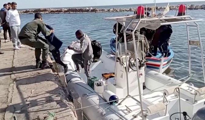 Un garde-côte national tunisien aide un enfant migrant à descendre d'un bateau de sauvetage à Jbeniana, Safx, Tunisie, le 23 avril 2022. (Reuters)