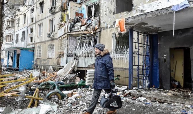 Un homme quitte un immeuble endommagé dans la deuxième plus grande ville d'Ukraine, Kharkiv qui est frappée en plein centre par un bombardement russe, le 8 mars 2022. (AFP)
