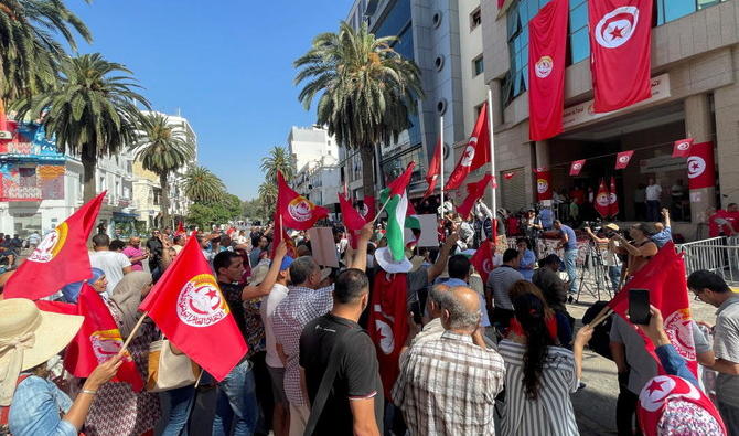 Les partisans de l'Union générale tunisienne du travail (UGTT) portent des drapeaux alors qu'ils se rassemblent lors d'une grève publique nationale devant leur siège à Tunis. (Reuters)