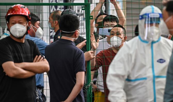 Des habitants en colère affrontent des fonctionnaires derrière une clôture érigée dans un complexe de quartier du district de Xuhui à Shanghai, le 6 juin 2022. (Photo, AFP)
