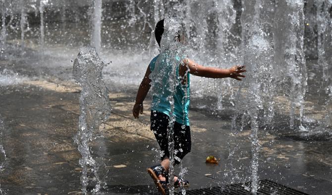 Un enfant se rafraîchit dans une fontaine du centre-ville de Montpellier, dans le sud de la France, le 14 juin 2022 alors qu'une vague de chaleur frappe la France. (Photo, AFP)