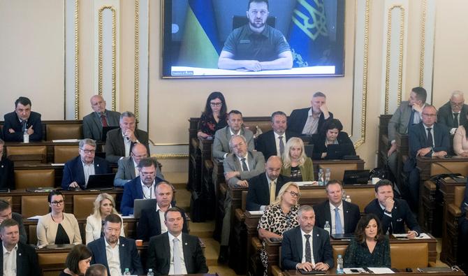 Le président ukrainien Volodymyr Zelensky est vu sur un écran alors qu'il s'adresse aux membres des deux chambres du Parlement tchèque par vidéoconférence à Prague, le 15 juin 2022. (Photo, AFP)
