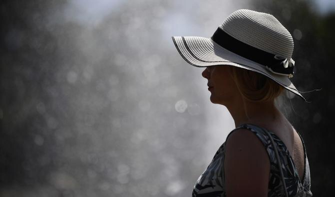 Une femme se rafraîchit aux fontaines du Trocadéro, au milieu des températures élevées à Paris, le 16 juin 2022. (Photo, AFP)