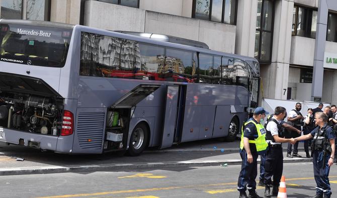 Des policiers se tiennent à côté d'un bus privé, après que son chauffeur est décédé après avoir perdu le contrôle du véhicule qui transportait des membres d'une communauté religieuse s'est écrasé sur la façade d'un immeuble près de la porte de Clichy à Paris, le 26 juin 2022. (Photo, AFP)