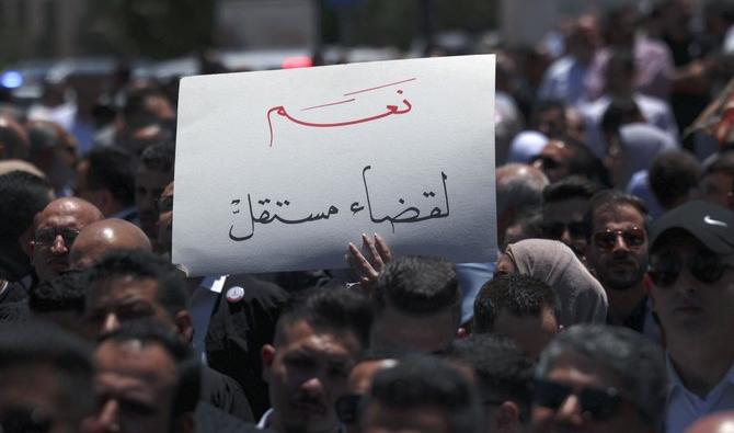Un manifestant brandit une pancarte sur laquelle on peut lire «Oui à un pouvoir judiciaire indépendant», lors d'un rassemblement d'avocats palestiniens à Ramallah, en Cisjordanie, le 25 juillet 2022. (Photo, AFP))