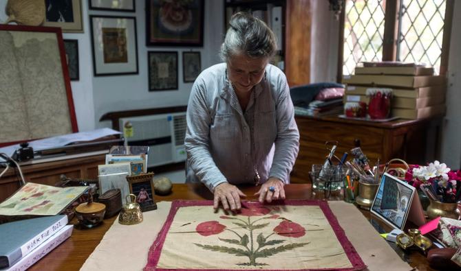 Brigitte Singh étend sur son bureau un carré d'étoffe moghol du XVIIe siècle, orné d'un grand pavot rouge. (Photo, AFP)