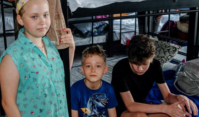 Trois enfants se reposent dans le nouveau centre de soutien ouvert pour les migrants de la région de Kherson à Zaporizhzhia, le 14 août 2022. (Photo, AFP)