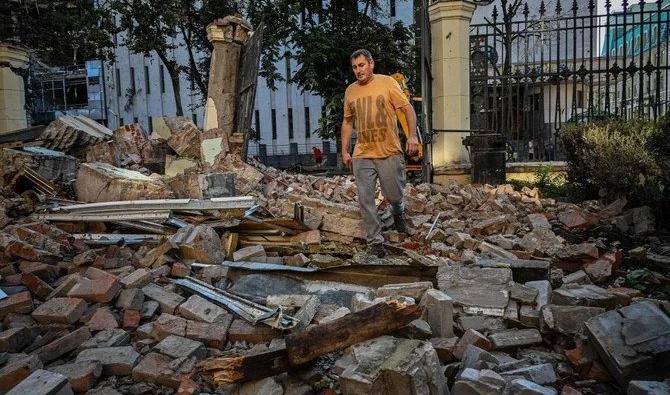 Un employé des services municipaux traverse les décombres d'un bâtiment détruit à la suite d'une frappe nocturne de missiles à Kharkiv, le 29 août 2022. (Photo, AFP)