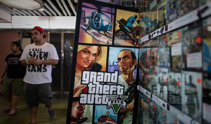 Un homme passe devant un panneau d'affichage du jeu vidéo «Grand Theft Auto V» à Hong Kong, le 17 septembre 2013. (Fichier, AFP) 