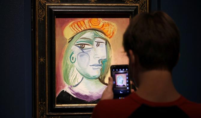 Un visiteur prend une photo de la peinture «Femme au béret rouge-orange» lors d'une exposition de peintures et de céramiques de Pablo Picasso à la Bellagio Gallery of Fine Art, le 21 octobre 2021 à Las Vegas, Nevada. (Photo, AFP)