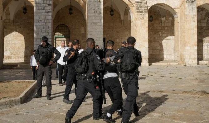 La police israélienne détient un Palestinien alors qu’elle escorte un groupe de colons juifs à l’intérieur de la mosquée Al-Aqsa dans la vieille ville de Jérusalem, mardi 27 septembre 2022. (Photo AP)
