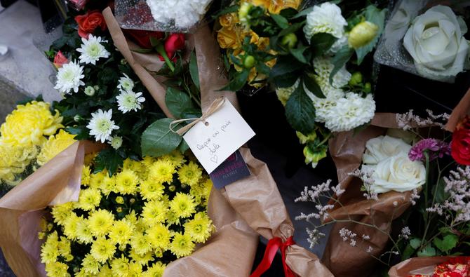 Des bouquets de fleurs avec un message manuscrit qui se lit comme suit «Repose en paix Lola», affichée à l'extérieur de l'immeuble à Paris le 17 octobre 2022, où vivait une écolière de 12 ans, prénommée Lola. (Photo, AFP)