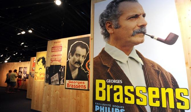 Des touristes regardent des affiches d'époque à l'espace Georges Brassens, lors des Fêtes de la Saint-Louis qui rendent hommage au chanteur sétois Georges Brassens par une série de concerts, expositions, festivals et documentaires. (Photo, AFP)