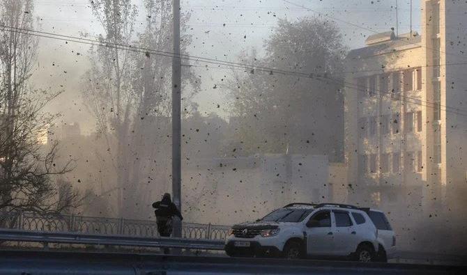 Un policier regarde des débris de pierre et de terre voler dans les airs alors que des drones kamikazes russes frappent le centre de la capitale Kiev, en Ukraine, le lundi 17 octobre 2022. (Photo, AP)