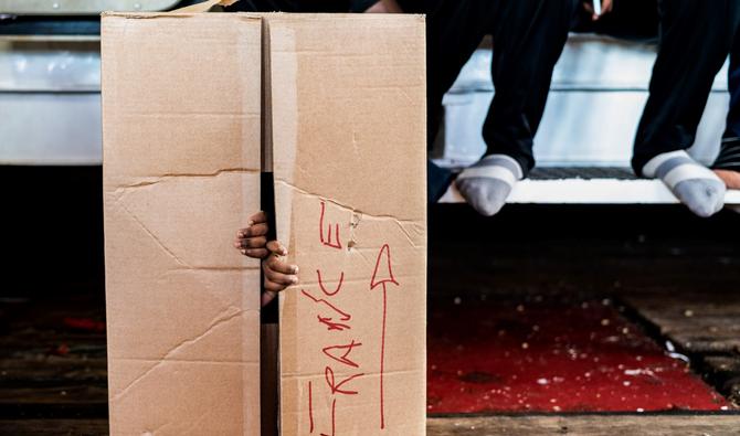 Un enfant migrant joue dans une boîte en carton portant l'inscription «France» à bord du navire de sauvetage Ocean Viking, le 10 novembre 2022, en mer Tyrrhénienne entre l'Italie et la Corse. (Photo, AFP)