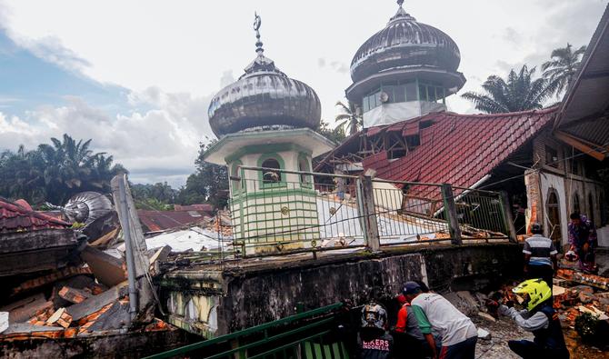 Des villageois tentent de communiquer avec les victimes sous les décombres d'une mosquée, à West Pasaman, le 25 février 2022. (Photo, AFP)