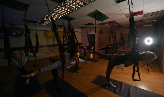 L'électricité et le chauffage étant coupés par des frappes russes sur les infrastructures énergétiques, les yogis sont vêtus des pulls épais et chaussettes en laine par-dessus leurs débardeurs et leurs leggings habituels. (Photo, AFP)