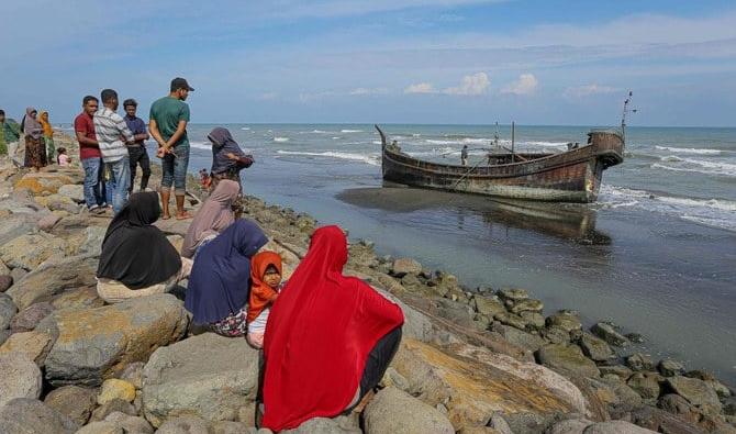 Des villageois regardent un bateau en bois utilisé par les Rohingyas à Pidie, dans la province d'Aceh, le 27 décembre 2022. (Photo, AFP)