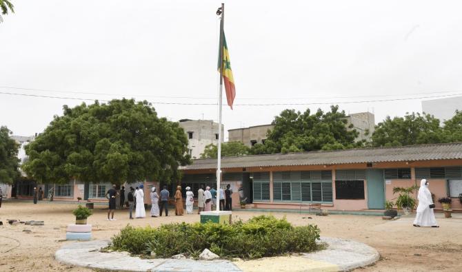 Les électeurs sénégalais font la queue, le 31 juillet 2022, devant un bureau de vote à Liberté 6, un quartier de Dakar, lors des élections législatives de juillet 2022 au Sénégal (Photo de SEYLLOU / AFP).
