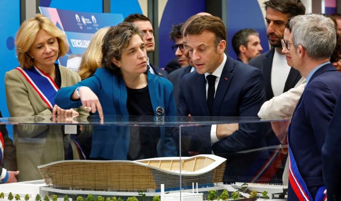 Le président français Emmanuel Macron observe une maquette lors d'une visite du centre aquatique olympique (CAO), un site multifonctionnel pour les Jeux olympiques de Paris 2024, le jour de son inauguration à Saint-Denis, en banlieue parisienne, le 4 avril 2024. (Photo, AFP)